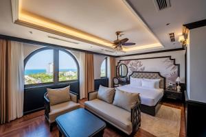 a bedroom with a bed and a couch and a window at Grand Luxury Hotel Ninh Chử in Thôn Mỹ Phước +94 photos