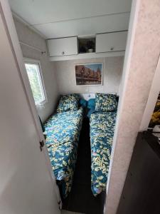 a small room with two beds in a tiny house at Mobilhome situé côté ville et côté campagne in Beaune