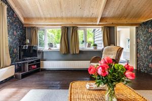 a living room with a vase of flowers on a table at Boshuis in Appelscha
