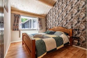 a small bedroom with a bed and a window at Boshuis in Appelscha