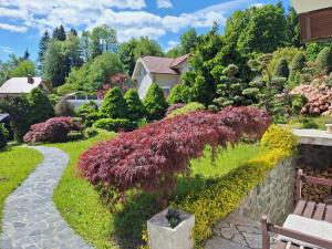 a garden with colorful flowers and a stone wall at Pohorje Zen Garden in Hočko Pohorje