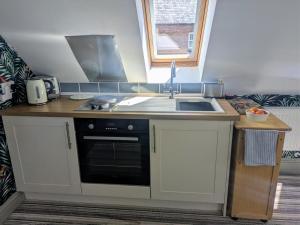 a kitchen with a sink and a stove at Intimate flat with free parking in Thorpe Langton