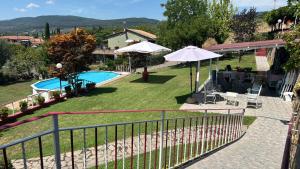 a view of a yard with a pool and umbrellas at La Cupoletta Holiday House -Magnolia in Trevignano Romano