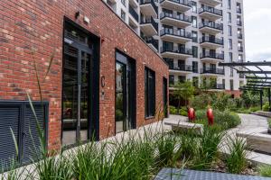 a red brick building with a building in the background at Central Paul Deluxe Apartment - by Open House in Timişoara