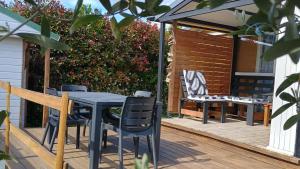 a patio with a table and chairs on a deck at CHALET Les ALGUES in Plobannalec-Lesconil