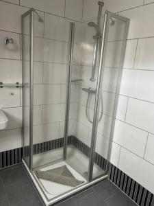 a shower with a glass door in a bathroom at Kiebitznest in Krummhörn