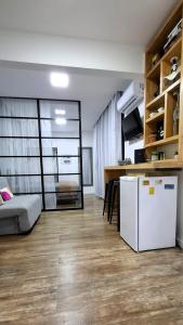 Una sala de estar con un refrigerador blanco y una mesa. en Apezinho.Loft, en Río de Janeiro