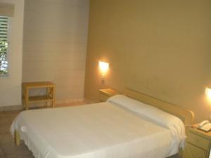 1 dormitorio con 1 cama blanca y 2 mesitas de noche en Hotel Barrancas San Pedro en San Pedro