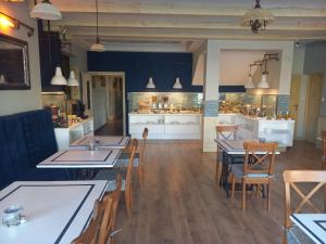 restauracja ze stołami i krzesłami oraz kuchnią w obiekcie Meander w Łebie
