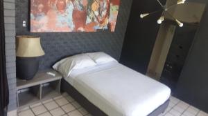 a bedroom with a bed and a table with a lamp at Torreón 3 - Habitación cerca del aeropuerto con alberca in Torreón +14 photos