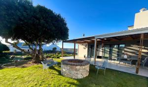 a house with a fire pit in the yard at 14 at Karee in Stilbaai
