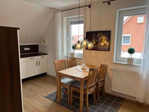 a kitchen and dining room with a table and chairs at Kiebitznest in Krummhörn