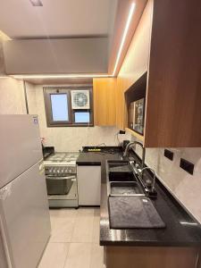 a kitchen with a sink and a refrigerator at madintay b8 modern cozy studio in Madinaty