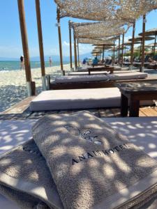 eine Gruppe von Betten an einem Strand mit Blick auf das Meer in der Unterkunft Anais Hotel in Korinós