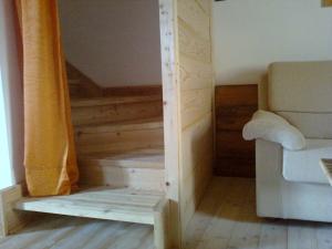 ヴェッツァーノにあるL'Abete Bianco Casa in montagnaの階段、ソファ、窓が備わる客室です。