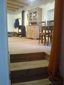 ヴェッツァーノにあるL'Abete Bianco Casa in montagnaのテーブルと椅子が備わるウッドフロアの客室です。