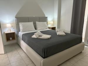 a bedroom with a bed with two towels on it at Emari Apartments in Heraklio