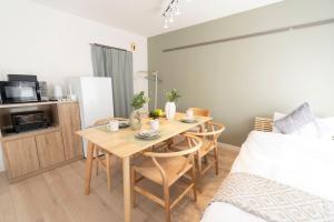 a room with a table and chairs and a bed at Alpha memory NAGOYA in Mutsunochō