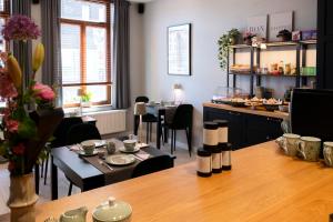 a room with a table and chairs and a kitchen at B&B De Koepoort in Mechelen