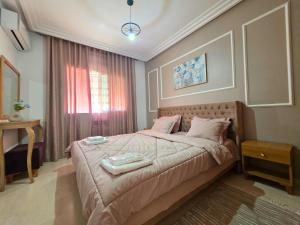 チュニスにあるLes jardins du lac 2のベッドと窓のある寝室