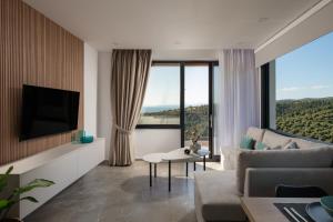 a living room with a couch and a tv at Amara Suites in Neos Marmaras