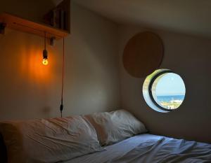 1 dormitorio con cama y ventana redonda en Rita's Apt&Rooms, en Noto