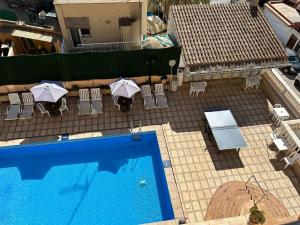 an overhead view of a swimming pool with chairs and umbrellas at Hostal San Telmo - Adults Only in Palma de Mallorca