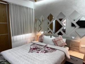 a bedroom with a bed and a wall with mirrors at Mirador Capo Negro in Cabo Negro +8 photos