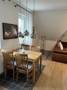 a living room with a wooden table and chairs at Kiebitznest in Krummhörn