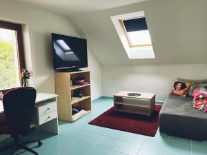a living room with a couch and a desk and a tv at Welcome Home in Kutná Hora