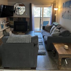 a living room with a couch and a fireplace at Renovated condo steps from Beaver Creek shuttle in Avon