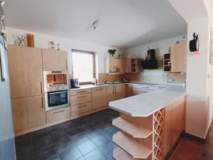 a kitchen with wooden cabinets and a marble counter top at Welcome Home in Kutná Hora