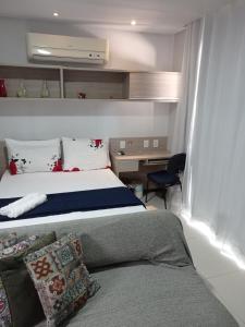 a bedroom with a bed and a desk with a chair at Bangalô jacuzzi Villas pratagy in Maceió +18 photos