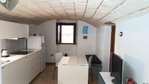 a kitchen with white cabinets and a tv on a counter at Dimora Pugliese in Monopoli