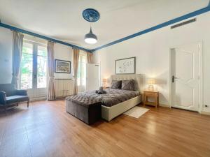 a bedroom with a bed and a chair in it at Bourgeois House - 16 personnes, Piscine, 6 chambres, 8 lits, 4 SDB, Centre-ville, CLIM in Salon-de-Provence