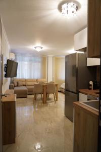 a kitchen and living room with a couch and a table at Neptun Apartments in Veliko Tŭrnovo