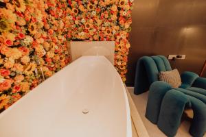 a room with two blue chairs and a wall with flowers at YUSU Hotel in Kata Beach