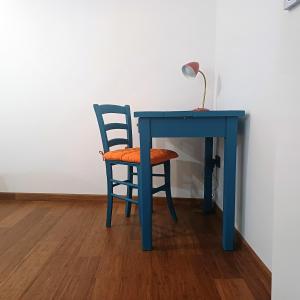 a blue desk with a chair and a lamp on it at Appartamento Diana in Orvieto