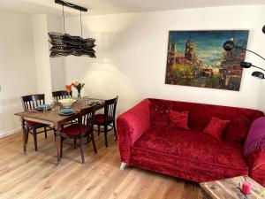 a living room with a red couch and a table at Ferienwohnung in Unterwössen in Unterwössen
