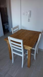 a wooden dining table with two white chairs around it at Loft céntrico in Santa Fe