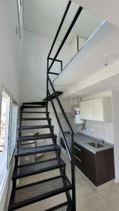 a black spiral staircase in a kitchen with a sink at Loft céntrico in Santa Fe