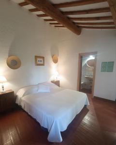 a bedroom with a white bed and a wooden floor at Pilgrim Rooms in Gubbio +41 photos