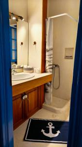 un bagno con lavandino, doccia e vasca di Stamos house a Hydra