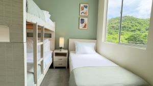 a bedroom with two bunk beds and a window at Descanso & Confort Girardot in Girardot