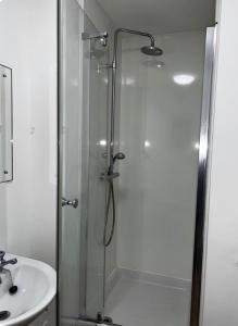 a shower with a glass door next to a sink at Modern studio in popular South Kensington location in London