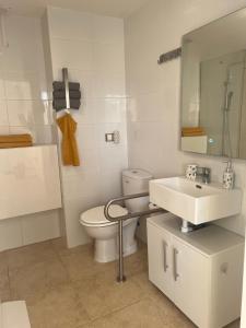 a white bathroom with a toilet and a sink at Apartmento Vista Piscina in Sant Jordi