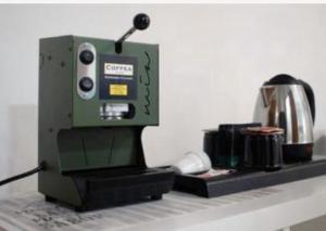 a green coffee maker sitting on top of a counter at Ginevra Rooms in Bari