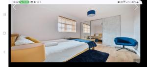 a bedroom with a bed and a blue chair at The Wheatland House in London