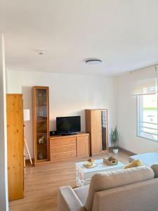 a living room with a couch and a tv at Apartamento Altamar Portonovo, 100 m playa in Sanxenxo