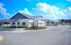 a large white building with umbrellas in a parking lot at Royal Golfview Stay in Boksburg